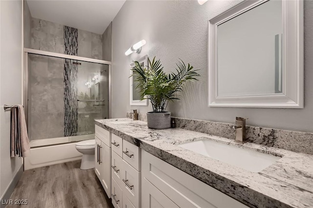 4740 W Agate Ave, Las Vegas, NV 89139 - bathroom with toilet, double vanity, wood finished floors, and shower / bath combination with glass door