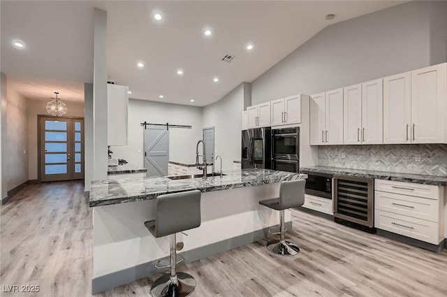 4740 W Agate Ave, Las Vegas, NV 89139 - kitchen featuring a sink, a barn door, appliances with stainless steel finishes, wine cooler, and light wood-type flooring