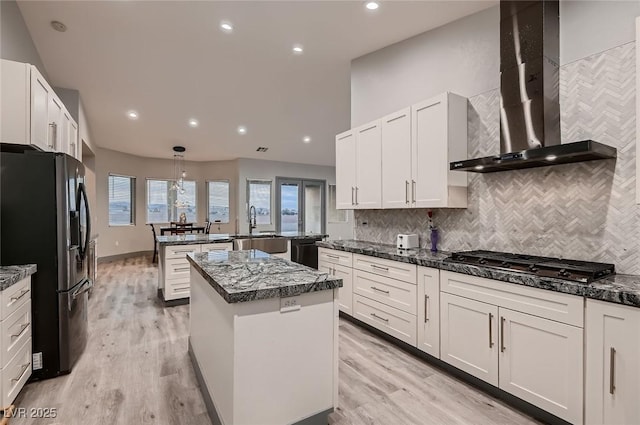 4740 W Agate Ave, Las Vegas, NV 89139 - kitchen featuring stainless steel fridge, wall chimney range hood, a center island, gas stovetop, and a sink