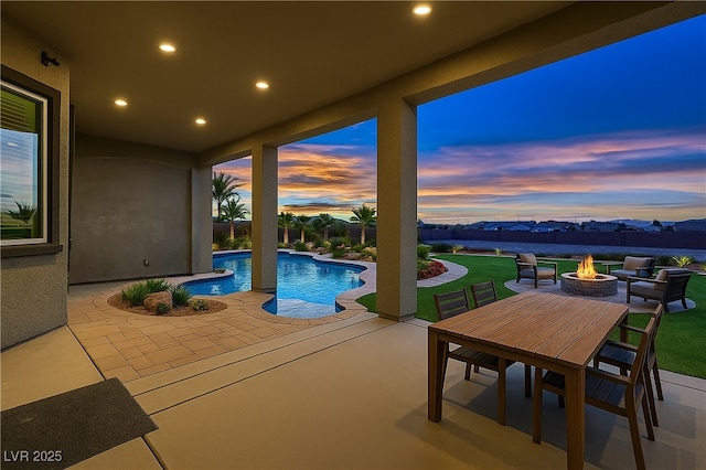 4740 W Agate Ave, Las Vegas, NV 89139 - pool at dusk featuring a patio, a fire pit, and a lawn