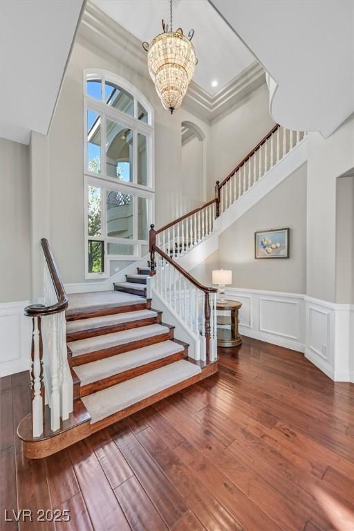 1809 White Hawk Ct, Las Vegas, NV 89134 - stairs with a decorative wall, hardwood / wood-style flooring, wainscoting, a chandelier, and ornamental molding