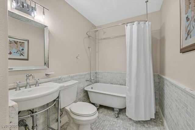 1809 White Hawk Ct, Las Vegas, NV 89134 - bathroom featuring wainscoting, toilet, tile walls, a sink, and a combined bath / shower with freestanding tub