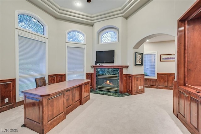 1809 White Hawk Ct, Las Vegas, NV 89134 - office featuring light colored carpet, arched walkways, wainscoting, a premium fireplace, and a tray ceiling