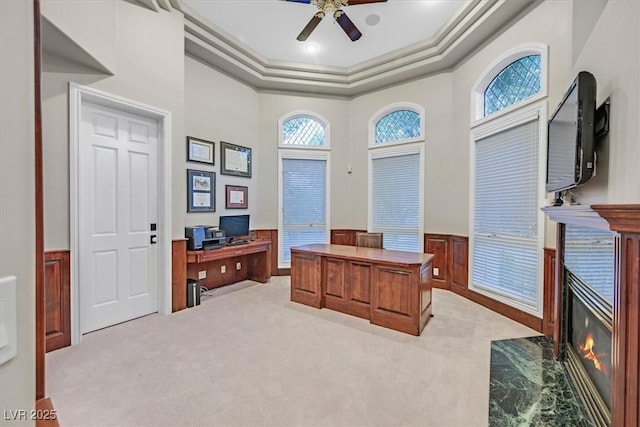 1809 White Hawk Ct, Las Vegas, NV 89134 - home office with a wainscoted wall, a ceiling fan, a premium fireplace, light carpet, and a raised ceiling