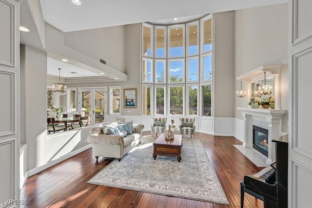 1809 White Hawk Ct, Las Vegas, NV 89134 - living room featuring a chandelier, a decorative wall, a towering ceiling, dark wood-type flooring, and a fireplace