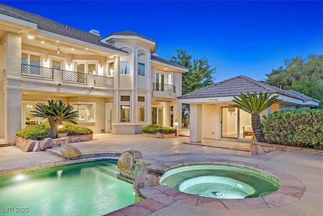 1809 White Hawk Ct, Las Vegas, NV 89134 - rear view of house featuring a balcony, a patio, an in-ground hot tub, stucco siding, and an outdoor pool