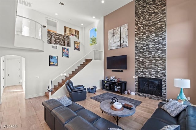 9301 Queen Charlotte Dr, Las Vegas, NV 89145 - living area with stairway, a fireplace, arched walkways, recessed lighting, and baseboards