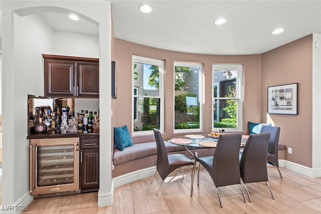 9301 Queen Charlotte Dr, Las Vegas, NV 89145 - dining space with beverage cooler, a bar, baseboards, arched walkways, and recessed lighting