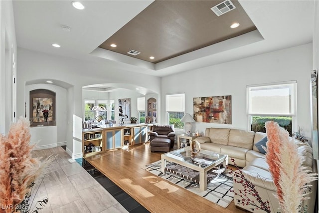 9301 Queen Charlotte Dr, Las Vegas, NV 89145 - living room featuring arched walkways, a raised ceiling, recessed lighting, and baseboards
