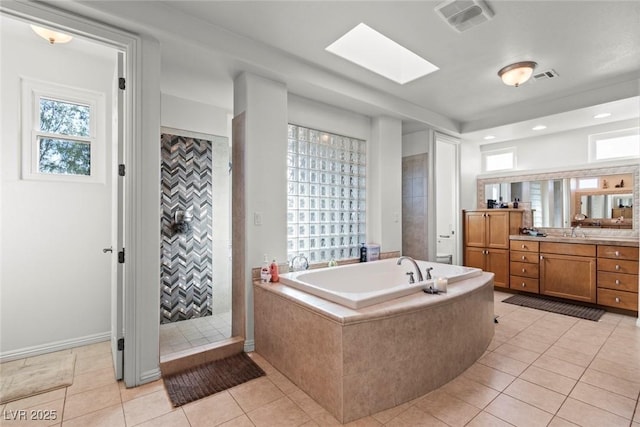 9301 Queen Charlotte Dr, Las Vegas, NV 89145 - full bath featuring a garden tub, vanity, tile patterned floors, tiled shower, and a skylight