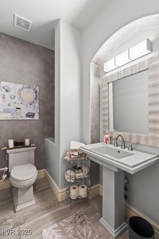 9301 Queen Charlotte Dr, Las Vegas, NV 89145 - bathroom featuring wood finished floors, toilet, and baseboards