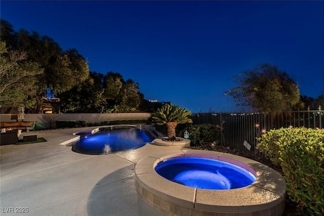 9301 Queen Charlotte Dr, Las Vegas, NV 89145 - pool at night featuring an in-ground hot tub, a fenced backyard, and a patio