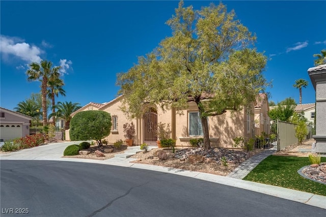 10361 Profeta Ct, Las Vegas, NV 89135 - obstructed view of property with stucco siding, a gate, and concrete driveway