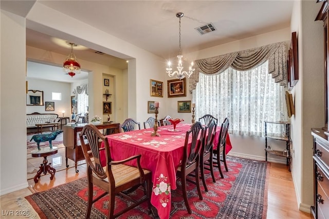10361 Profeta Ct, Las Vegas, NV 89135 - dining area featuring plenty of natural light, a chandelier, light wood-style flooring, and baseboards