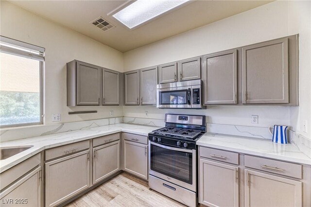 7900 Dutch Canyon Ct, Las Vegas, NV 89131 - kitchen with appliances with stainless steel finishes, gray cabinets, and light wood-type flooring