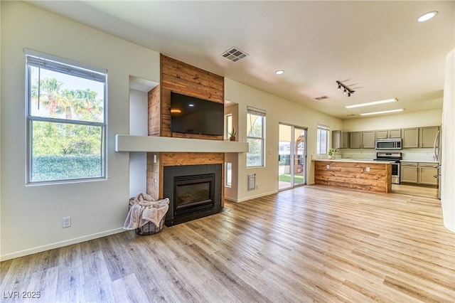 7900 Dutch Canyon Ct, Las Vegas, NV 89131 - unfurnished living room with a large fireplace, light wood finished floors, rail lighting, and recessed lighting
