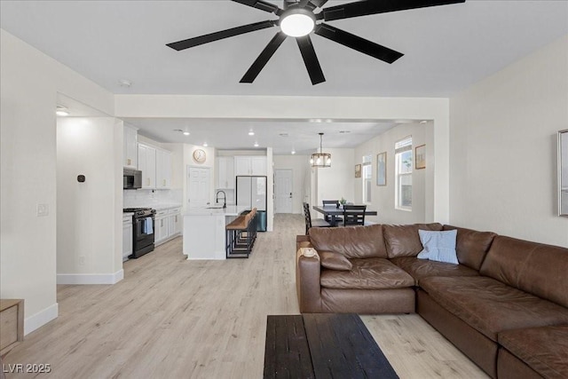 4030 Midnight Crest Ave, North Las Vegas, NV 89031 - living area featuring light wood finished floors, ceiling fan, a chandelier, and baseboards