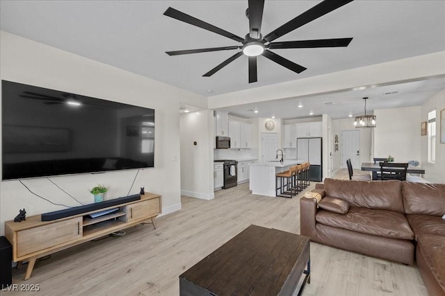 4030 Midnight Crest Ave, North Las Vegas, NV 89031 - living room featuring light wood-style flooring, a chandelier, ceiling fan, baseboards, and recessed lighting