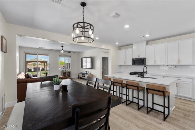 4030 Midnight Crest Ave, North Las Vegas, NV 89031 - dining room featuring light wood-type flooring, a ceiling fan, recessed lighting, a chandelier, and baseboards