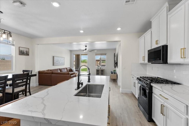 4030 Midnight Crest Ave, North Las Vegas, NV 89031 - kitchen featuring a sink, black range with gas cooktop, light wood-type flooring, white cabinetry, and ceiling fan