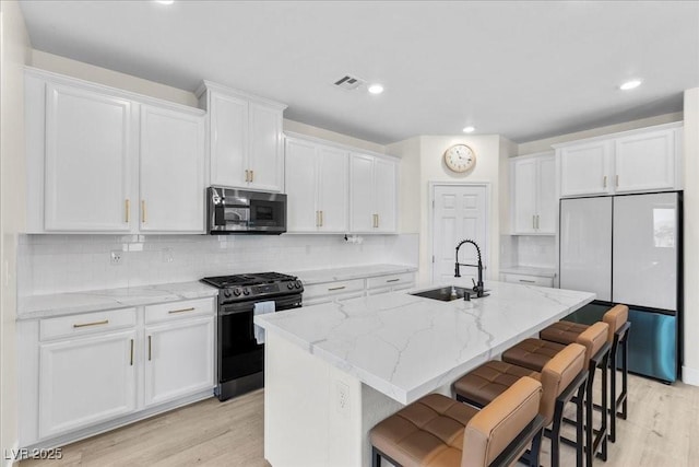 4030 Midnight Crest Ave, North Las Vegas, NV 89031 - kitchen with range with gas cooktop, stainless steel microwave, fridge, a sink, and light wood-style flooring