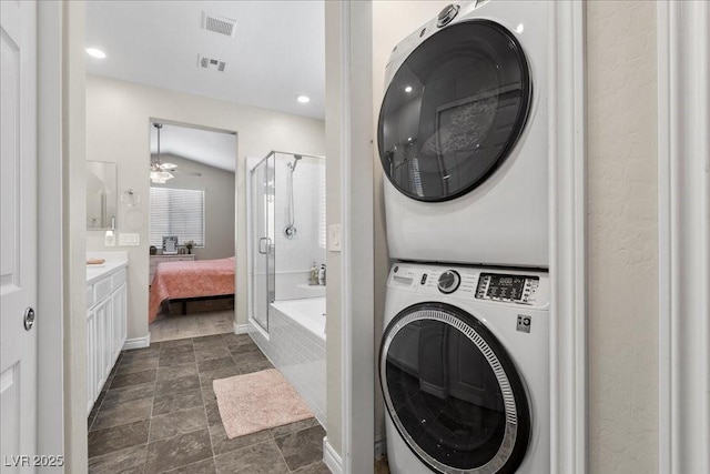 4030 Midnight Crest Ave, North Las Vegas, NV 89031 - laundry room with stacked washer and clothes dryer, recessed lighting, and dark stone finish floors
