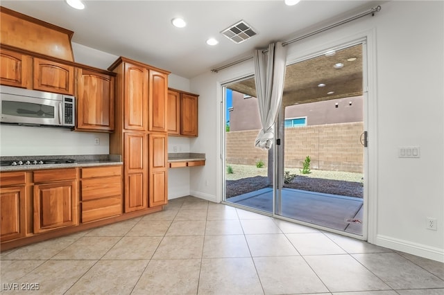 512 Los Dolces St, Las Vegas, NV 89138 - kitchen with stainless steel microwave, baseboards, gas cooktop, brown cabinetry, and recessed lighting