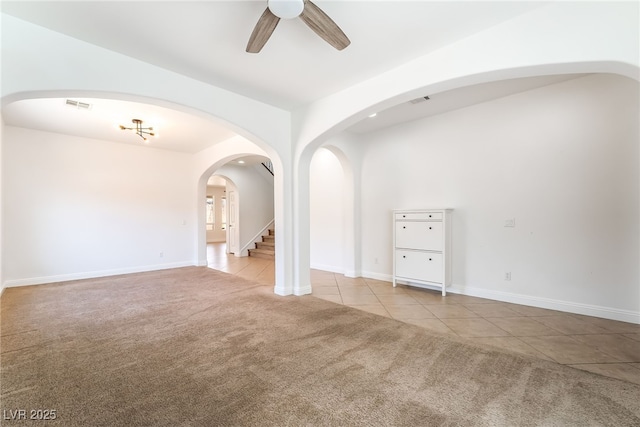 512 Los Dolces St, Las Vegas, NV 89138 - carpeted empty room with ceiling fan, tile patterned flooring, stairs, baseboards, and arched walkways