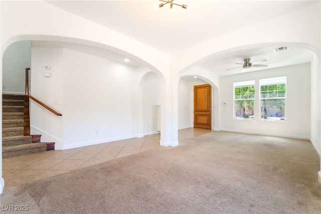 512 Los Dolces St, Las Vegas, NV 89138 - unfurnished living room featuring carpet floors, a ceiling fan, arched walkways, stairway, and tile patterned floors
