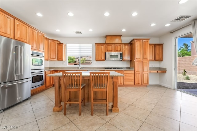 512 Los Dolces St, Las Vegas, NV 89138 - kitchen with appliances with stainless steel finishes, a kitchen island, recessed lighting, a breakfast bar, and light tile patterned flooring
