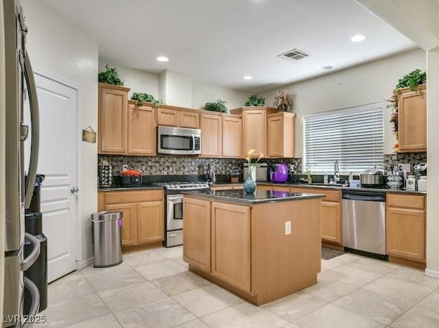 5507 Gemini Bridges St, Las Vegas, NV 89130 - kitchen with stainless steel appliances, dark countertops, tasteful backsplash, a center island, and recessed lighting