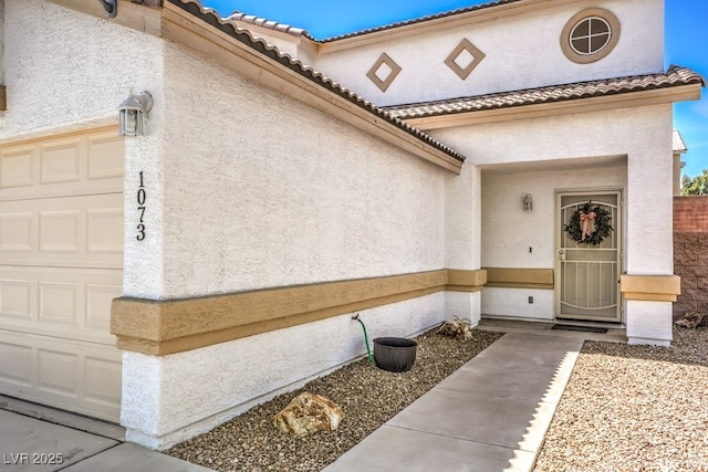 1073 Nordyke Ave, Henderson, NV 89015 - entrance to property with an attached garage, stucco siding, and a tiled roof