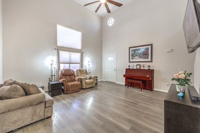1073 Nordyke Ave, Henderson, NV 89015 - living area featuring a ceiling fan, a high ceiling, healthy amount of natural light, light wood-style flooring, and baseboards