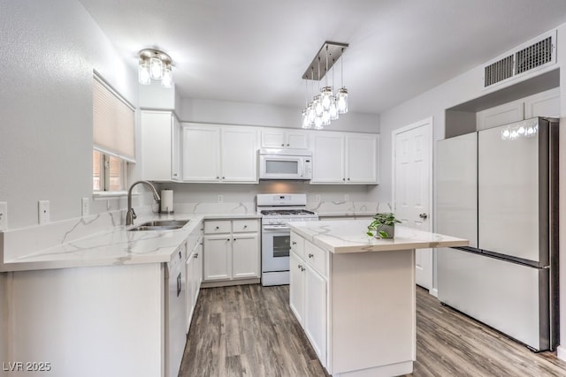 1073 Nordyke Ave, Henderson, NV 89015 - kitchen with white appliances, a sink, wood finished floors, and light stone counters