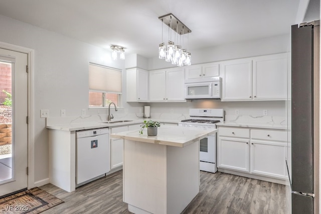 1073 Nordyke Ave, Henderson, NV 89015 - kitchen with white appliances, a sink, light wood finished floors, white cabinetry, and light stone countertops