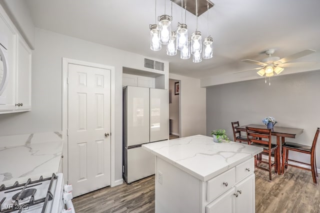 1073 Nordyke Ave, Henderson, NV 89015 - kitchen with freestanding refrigerator, wood finished floors, range, and a kitchen island