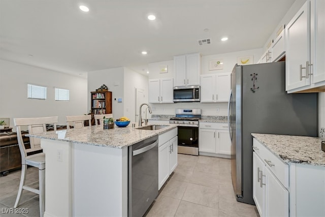 392 Canary Song Dr, Henderson, NV 89011 - kitchen featuring appliances with stainless steel finishes, a sink, a breakfast bar area, white cabinetry, and recessed lighting