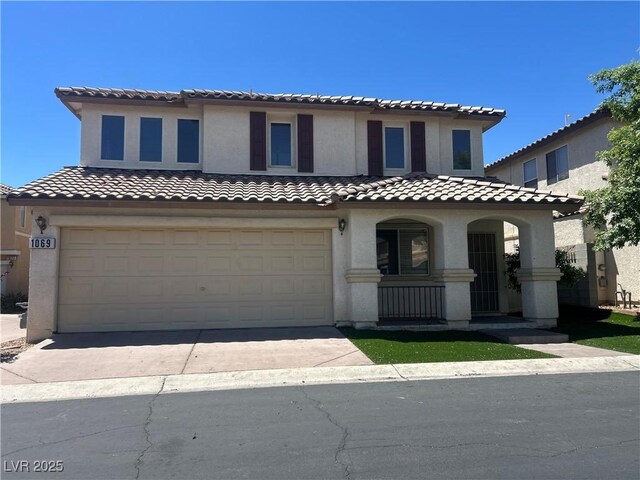 1069 Coronado Peak Ave, Las Vegas, NV 89183 - mediterranean / spanish house with a garage, stucco siding, concrete driveway, a porch, and a tiled roof