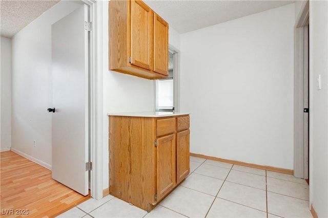 4205 Thicket Ave, North Las Vegas, NV 89031 - kitchen featuring light countertops, baseboards, a textured ceiling, and light wood-type flooring