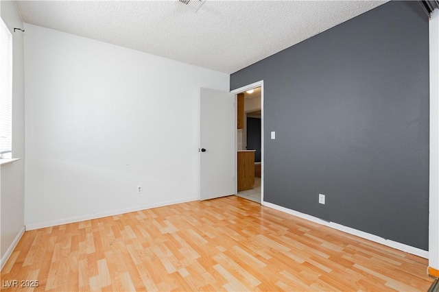 4205 Thicket Ave, North Las Vegas, NV 89031 - empty room with light wood-style flooring, a textured ceiling, and baseboards