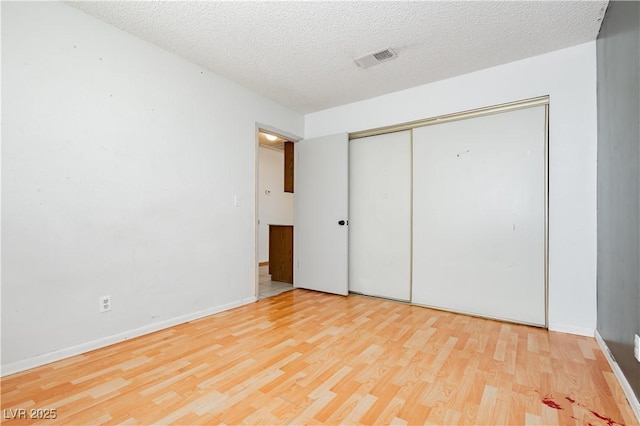 4205 Thicket Ave, North Las Vegas, NV 89031 - unfurnished bedroom with wood finished floors, a textured ceiling, a closet, and baseboards