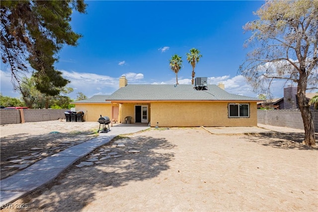 4205 Thicket Ave, North Las Vegas, NV 89031 - rear view of house with a patio area, stucco siding, a fenced backyard, a chimney, and central AC