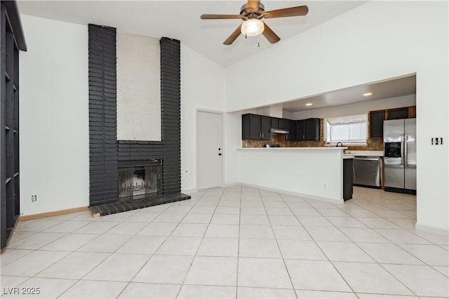 4205 Thicket Ave, North Las Vegas, NV 89031 - unfurnished living room featuring a ceiling fan, a fireplace, high vaulted ceiling, baseboards, and light tile patterned floors