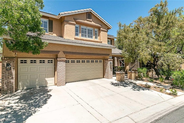 10744 Balsam Creek Ave, Las Vegas, NV 89144 - view of front of house with a garage, brick siding, stucco siding, concrete driveway, and a tile roof