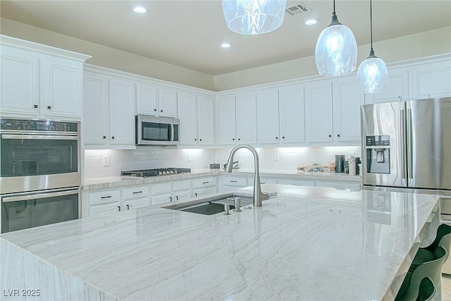 10744 Balsam Creek Ave, Las Vegas, NV 89144 - kitchen with appliances with stainless steel finishes, a sink, a large island, white cabinets, and recessed lighting