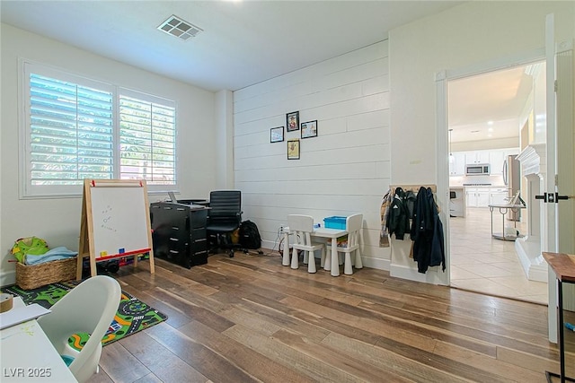 10744 Balsam Creek Ave, Las Vegas, NV 89144 - playroom featuring light wood finished floors, wooden walls, and a desk