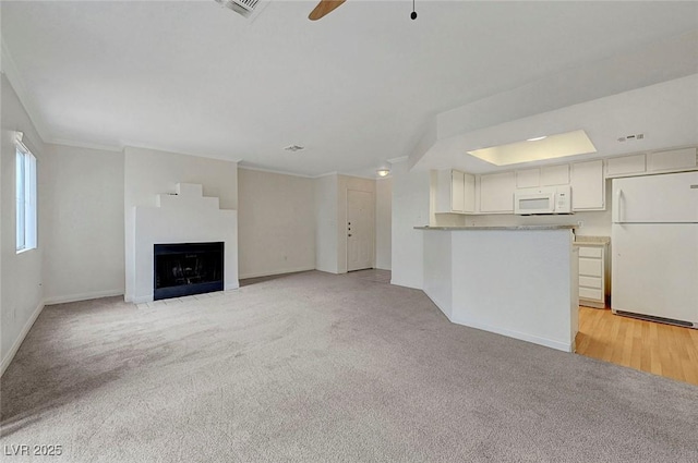 8600 W Charleston Blvd Unit 1128, Las Vegas, NV 89117 - unfurnished living room featuring crown molding, light carpet, a fireplace, baseboards, and a ceiling fan