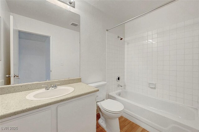 8600 W Charleston Blvd Unit 1128, Las Vegas, NV 89117 - full bathroom featuring toilet, wood finished floors, vanity, and bathtub / shower combination