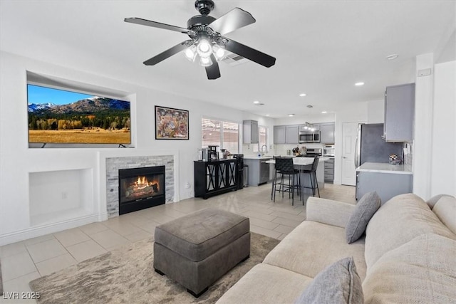 600 Beresford Ave, Las Vegas, NV 89123 - living room with light tile patterned floors, ceiling fan, a fireplace, and recessed lighting