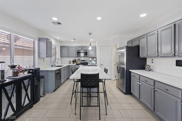 600 Beresford Ave, Las Vegas, NV 89123 - kitchen with stainless steel appliances, gray cabinetry, a sink, tasteful backsplash, and light countertops